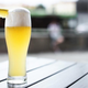 Wheat beer with slice of lemon on patio table